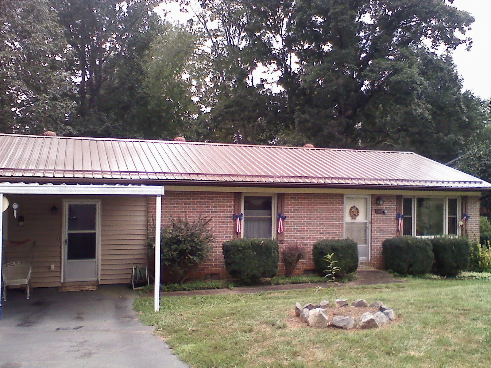 Bronze metal roof and carport on a brick ranch home — Roof Repair work by our crew in Clayton