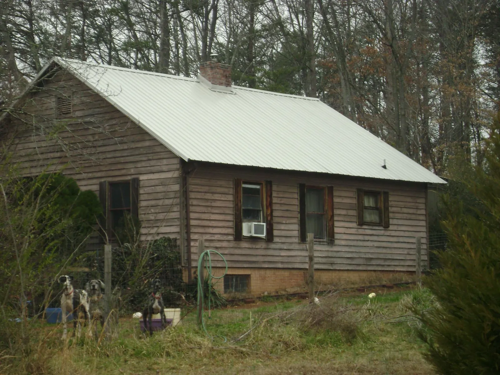 White metal roof on an old wood sided farmhouse, from a Metal Roof Installation job in Clayton